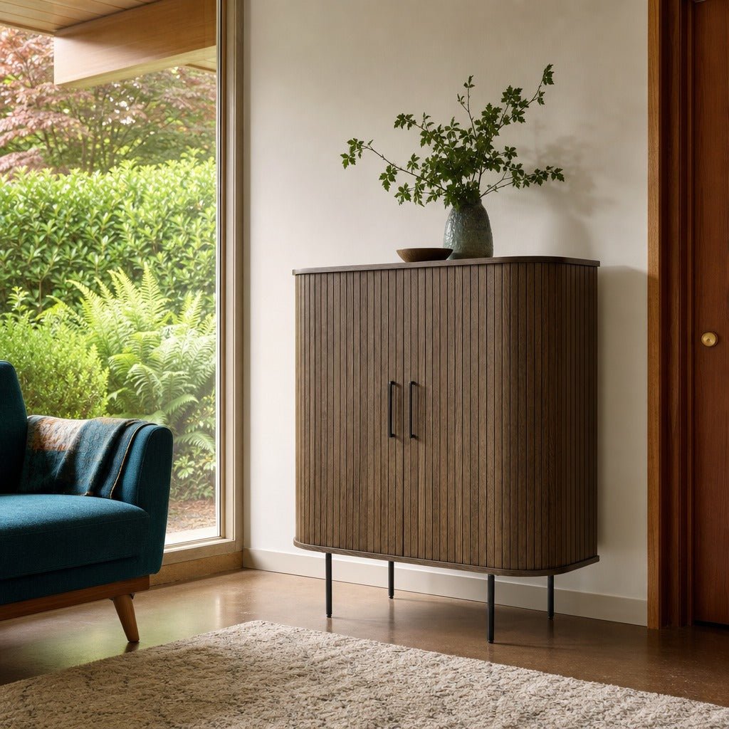 Nola Cabinet in Smoked Oak by a garden window with a blue chair - Whats New Furniture