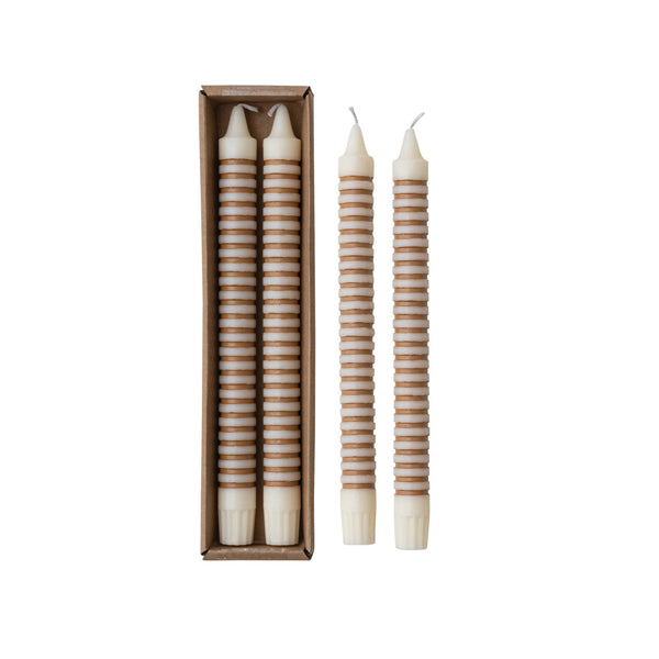 Tan striped taper candles in their box beside the pair of candles