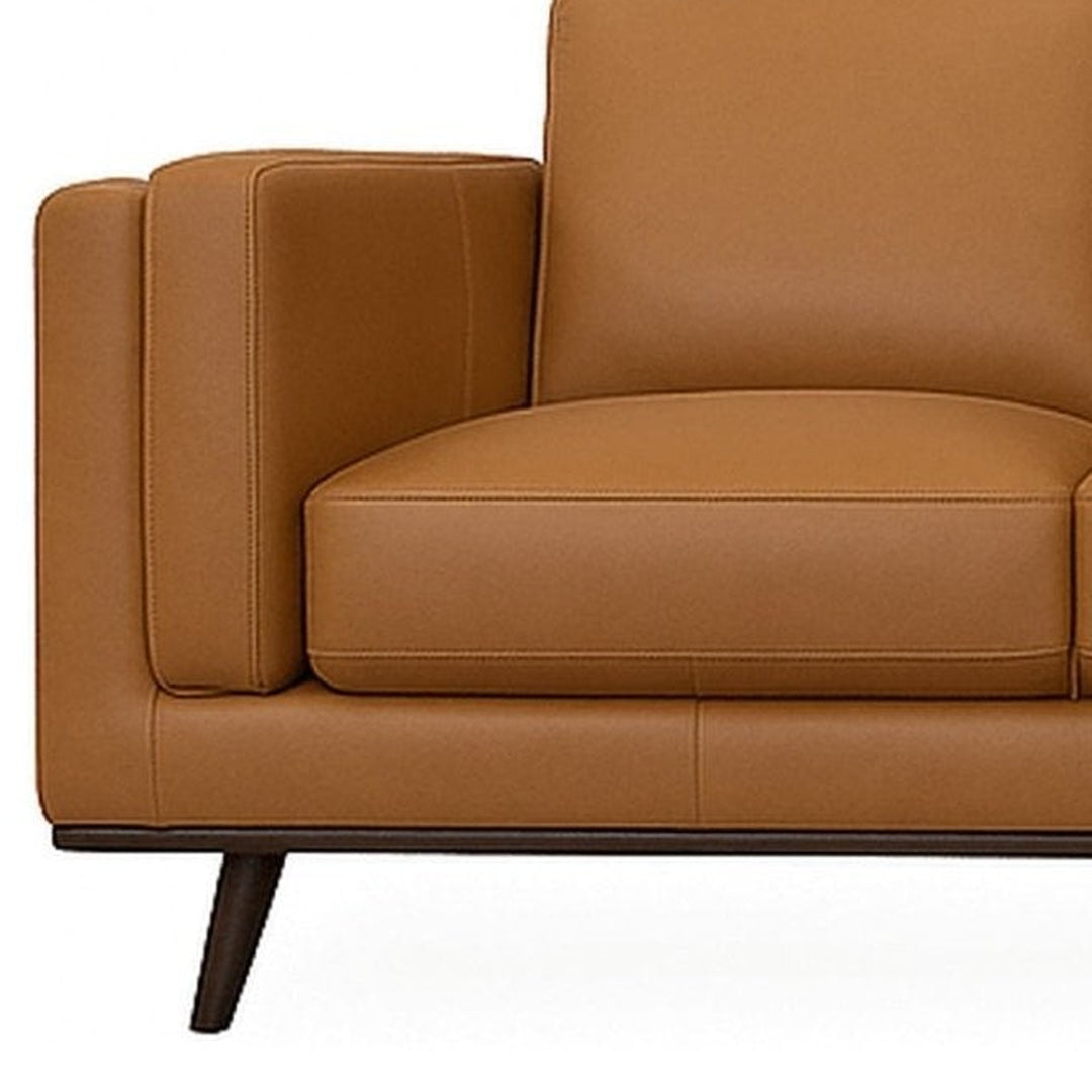 Close-up of the side pillow slotted against the inner face of the arm on the camel Eager leather sofa - What&