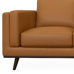 Close-up of the side pillow slotted against the inner face of the arm on the camel Eager leather sofa - What&