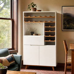 White mid-century Article bar cabinet with a tall slim silhouette and paneled doors. - detail view 1