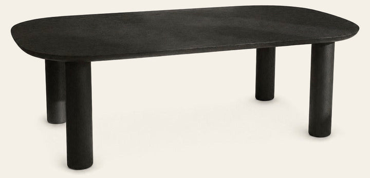 Monsun 47 inch rectangular coffee table in black oak with four cylindrical legs, studio view