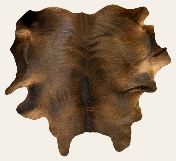 Genuine brown cowhide area rug, full hide shown from above on a white studio background.