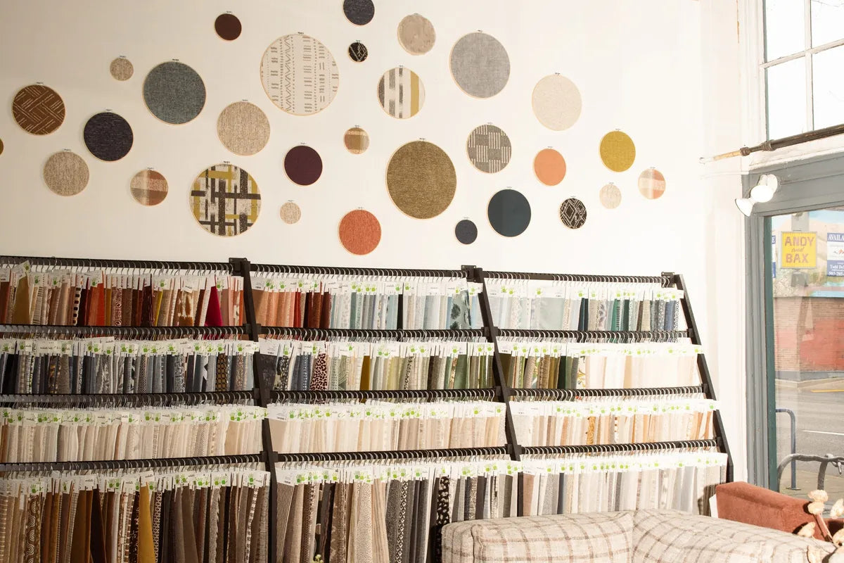 The fabric wall at What's New Furniture's Portland store: rows of hanging upholstery samples under a cluster of round fabric hoops